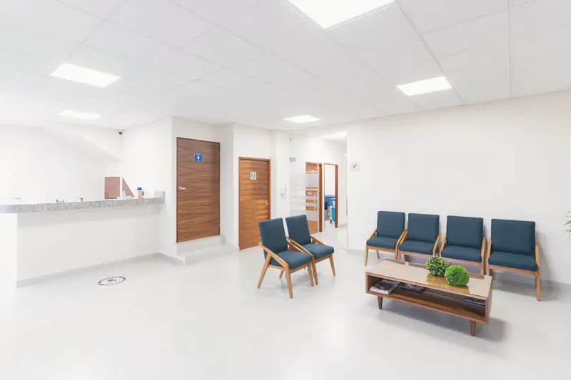 Svetla čekaonica sa recepcijom i plavim stolicama
